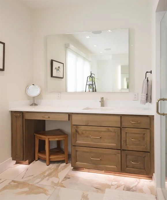 Warm stained knotty alder bathroom vanity with a make-up station and white quartz top