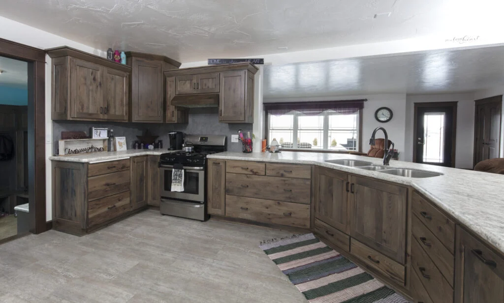 Rustic knotty hickory kitchen cabinetry in a grey-brown stain with speckled granite counters