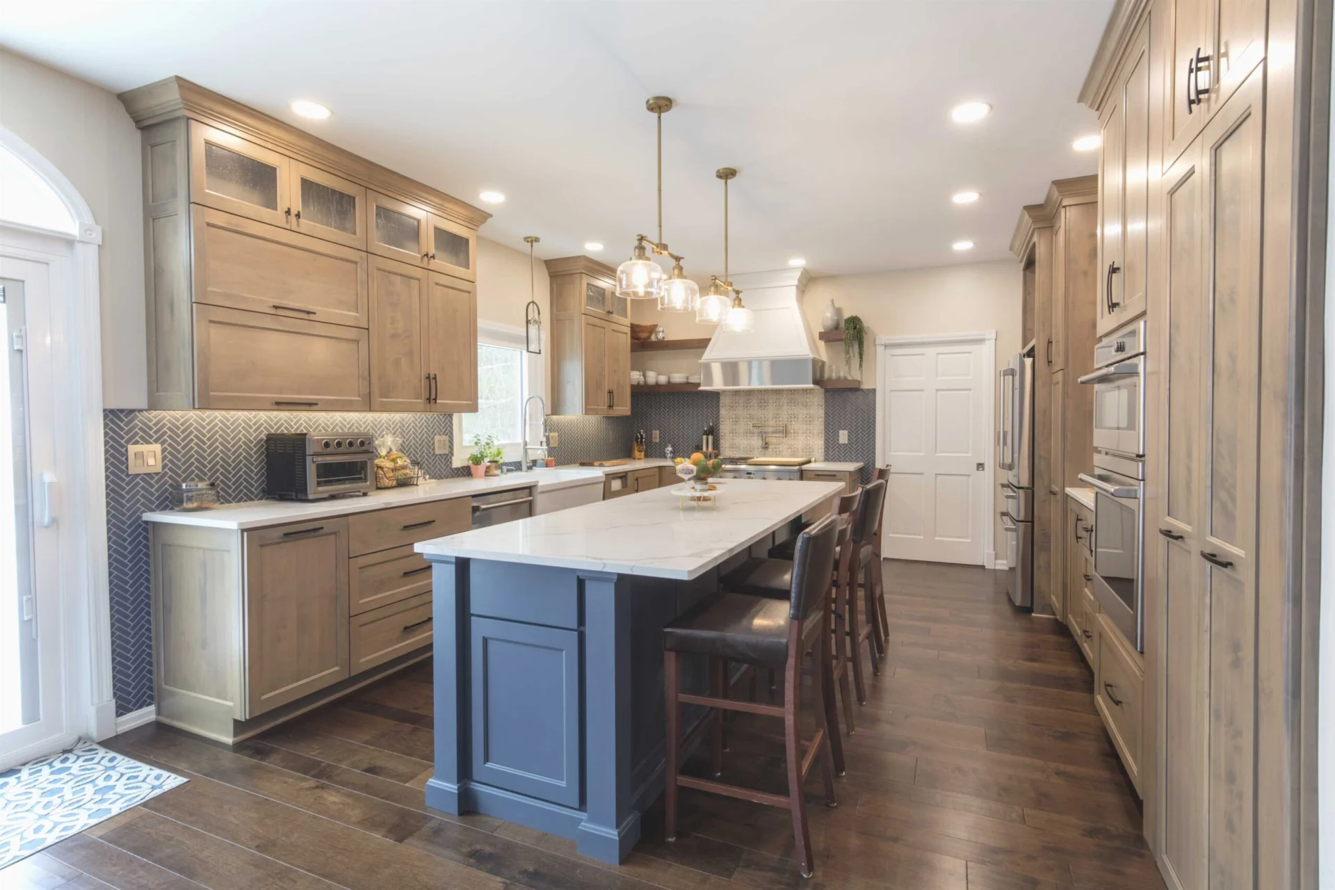 Warm honey-stained maple kitchen cabinetry with a slate blue painted island